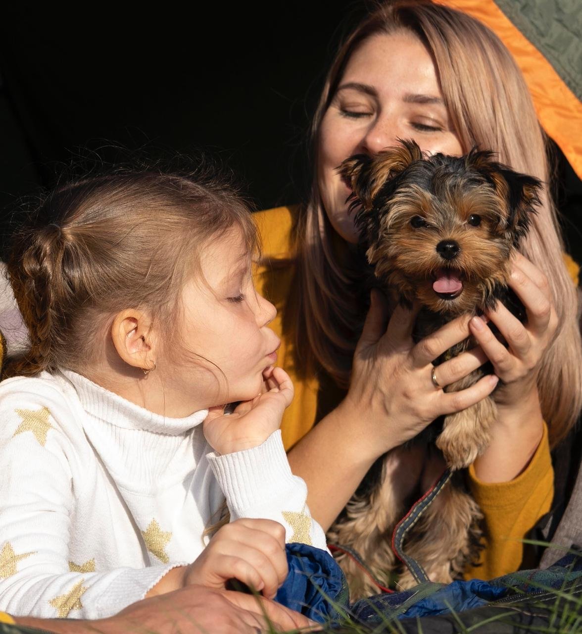 Girl and woman holding a Yorkshire terrier puppy