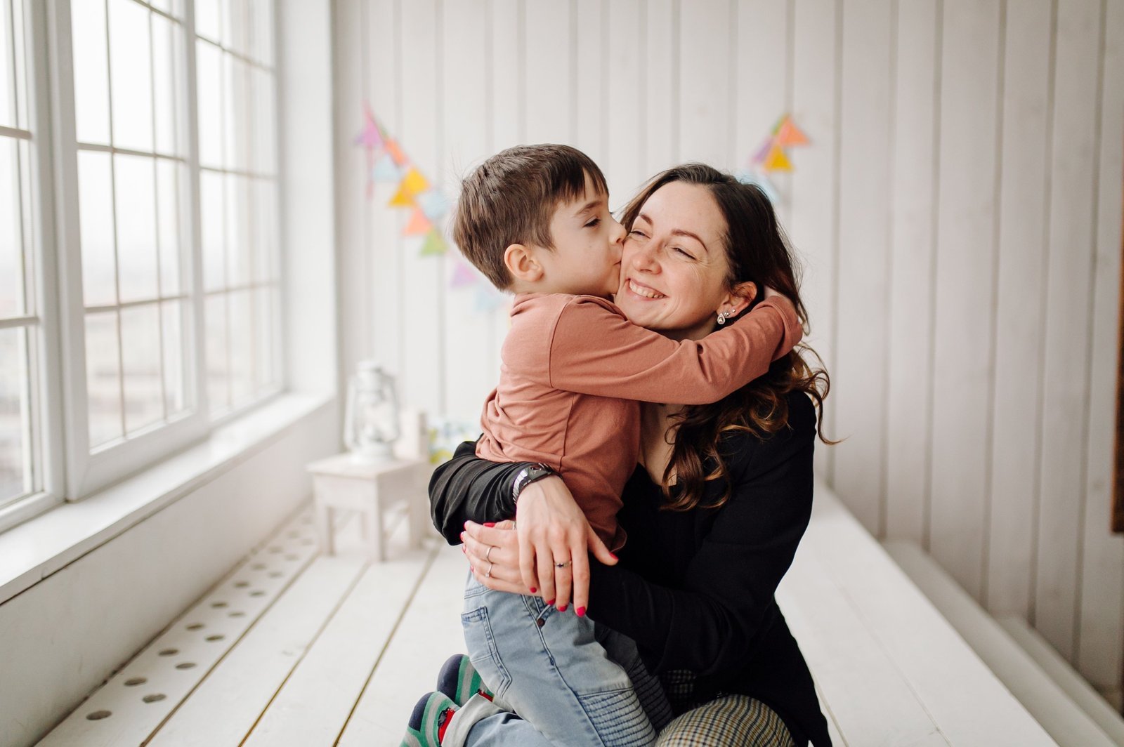 Woman hugging a young boy who kisses her cheek
